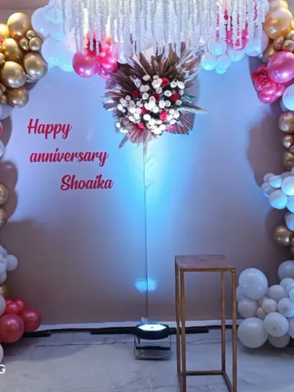 A festive anniversary backdrop for "Shoaika." I designed a balloon arch in shades of pink, gold, and white, with a floral centerpiece and hanging crystals.
