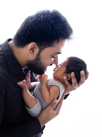 The color version of the father and newborn portrait. The natural skin tones and soft lighting create a warm and lifelike image that is just as powerful as the black and white version.