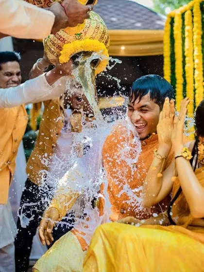 The Haldi ceremony is all about fun, and we're right there in the middle of it. This action shot captures the playful splash and the couple's amazing reaction, a memory they'll laugh about for years.
