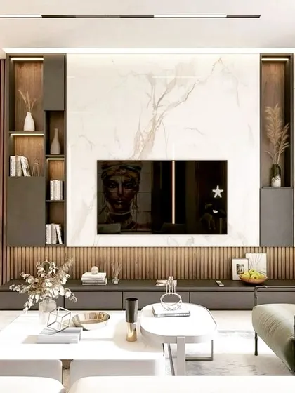 A modern living room centered around a custom media wall. This entertainment unit features a full-height marble backsplash, flanked by integrated wood-paneled shelving with internal lighting, creating a perfect balance of texture and luxury.