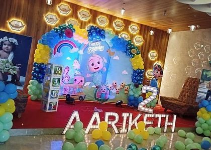 Another angle of the large Cocomelon party, showing how photo posters of the birthday boy can be integrated into the overall stage design.