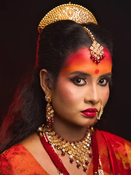 A close-up of the Maa Katyayani look, highlighting the fiery colors used on the forehead and the intense gaze.