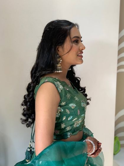 A side profile of Bhakti's bridesmaid look, showing off her soft curls and statement jhumkas.
