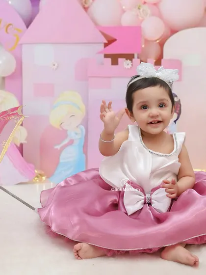A little princess waving from her castle. This Disney princess theme, complete with a castle backdrop, is perfect for creating fairytale portraits.