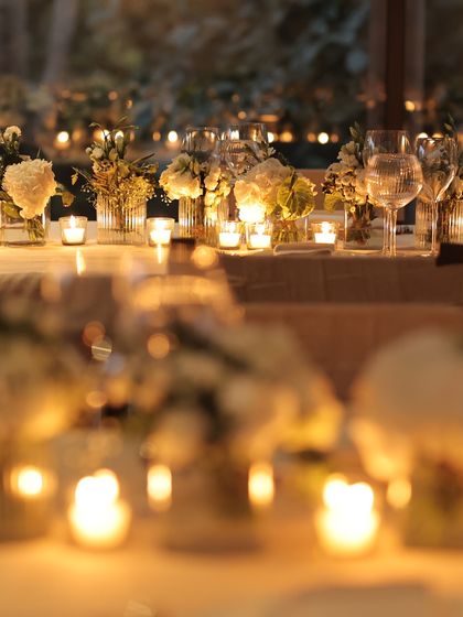 A long shot of the candlelit table, with the lights creating a beautiful bokeh effect. This image evokes a sense of dreamlike romance and celebration.