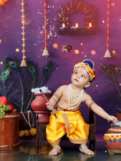 I bring cultural celebrations to life with themed photoshoots like this Little Krishna session. Dressed in traditional attire with a flute and peacock feathers, this little boy looks up in wonder, creating a divine and memorable image.