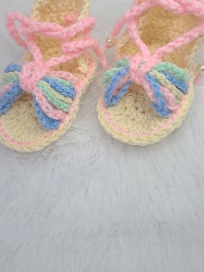 A top-down view of the pastel rainbow sandals, showing the cute bow detail on the front.