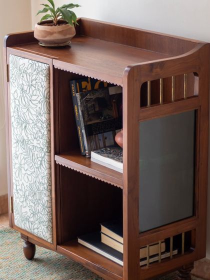 The Aamira storage unit is a piece with details galore. It can function as a bookcase, crockery unit, or bar, and features finger grooves, stained glass, and brass inserts, making it a statement piece for any living or dining area.
