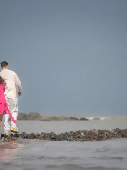 Walking into their future together. This shot from a pre-wedding session captures a sense of journey and partnership against the vast ocean.