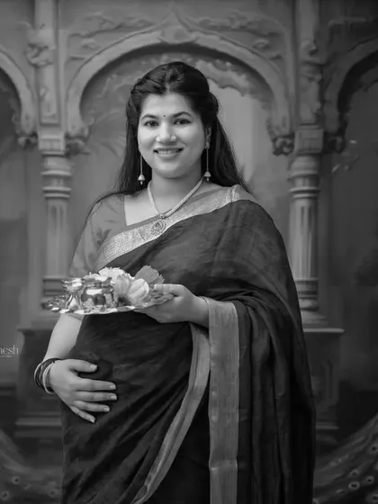 This black and white portrait against the peacock-themed backdrop is striking. It blends traditional attire with a classic photography style for a truly artistic result.
