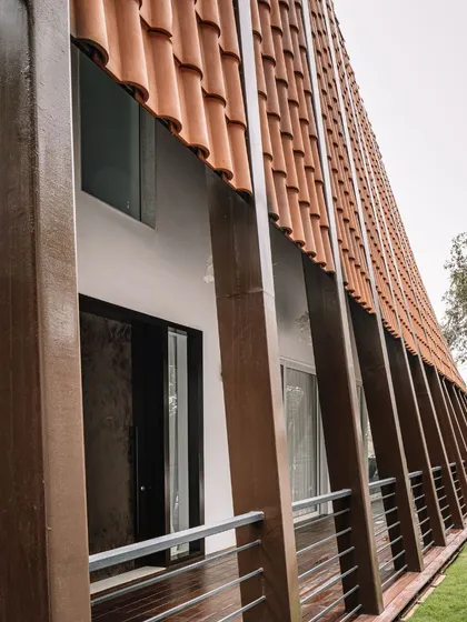 A close-up of the Tellado Villas' facade, showcasing the unique application of red mission tiles on a curved surface. This detail is a testament to our approach of blending heritage-inspired materials with a fresh, contemporary twist.