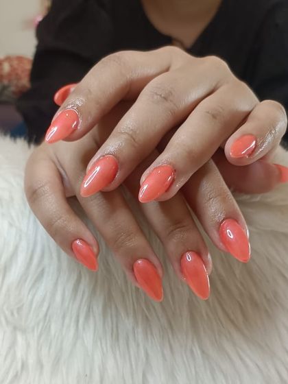 A recap photo of a lovely coral-orange polish on almond nails.