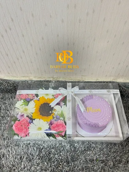 The cake and flower tray packaged in a clear box with a ribbon, ready to be gifted.