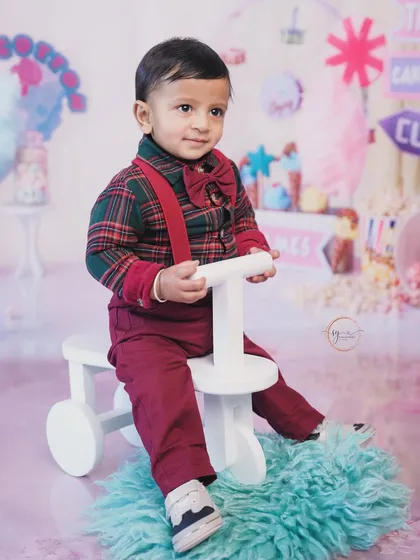 Dressed in a festive plaid shirt and red suspenders, this little star is celebrating his first birthday with a fun carnival-themed setup.