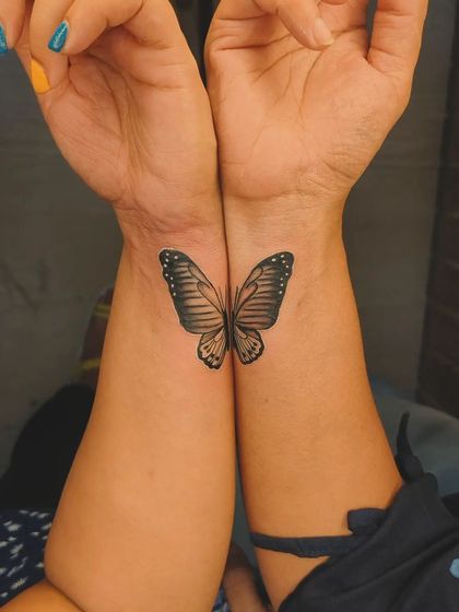A matching butterfly tattoo designed to be complete when two friends bring their arms together. A creative take on a friendship tattoo.