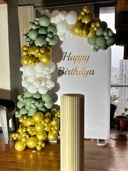 This simple backdrop with a balloon half-arch in olive green, gold, and white is perfect for smaller spaces. It provides a beautiful spot for photos without overwhelming the room.