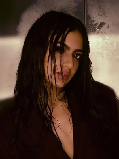 A slightly different angle of the wet look, showing how it can be styled to look both fierce and elegant. The makeup remains the focal point, with its dark, dramatic eyes.