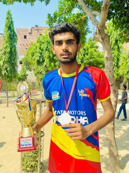 A proud player showcasing his first-place trophy and medal from a local tournament.