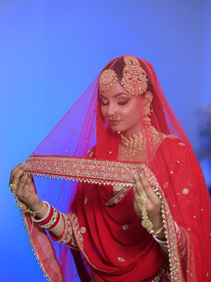 The bride with her veil. The red colour is so vibrant and the makeup is designed to stand out beautifully against it.