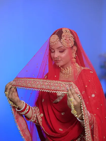 The bride with her veil. The red colour is so vibrant and the makeup is designed to stand out beautifully against it.