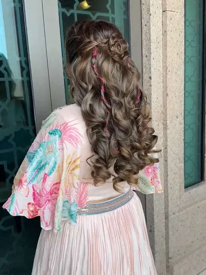 Loosely curled hair laced with pink threads for a festive sparkle. This creative hairstyle was the perfect finishing touch for a fun carnival-themed event.