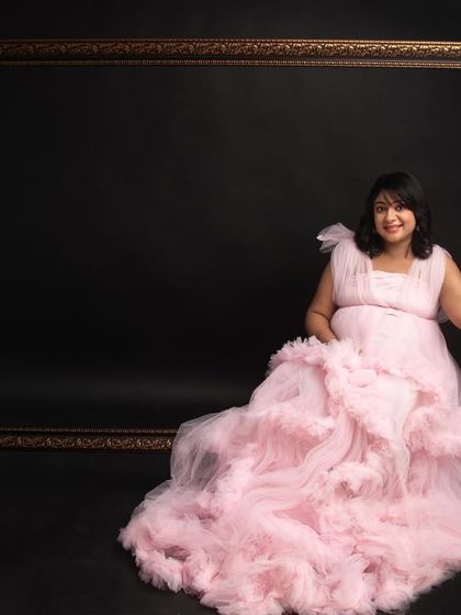 A lovely solo portrait with the empty frame prop. The mom-to-be's joyful expression and the beautiful ruffled gown make this a sweet and creative shot.