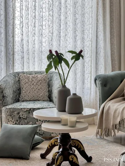 A serene corner styled with soft textures and natural light. The floral armchair, nested coffee tables, and a touch of greenery create a peaceful and elegant spot to relax.