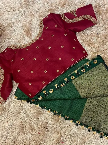The front of the maroon blouse, showing the delicate buttis and the embroidered neckline, a perfect match for the green saree.