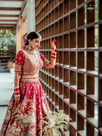 A beautiful portrait of the bride in her red lehenga, her pose and expression exuding grace and elegance.