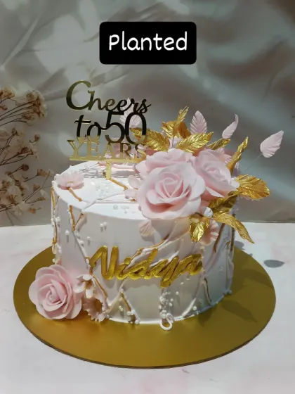 Another look at this stunning 50th birthday cake, highlighting the intricate details of the sugar flowers and gold accents against the textured buttercream.