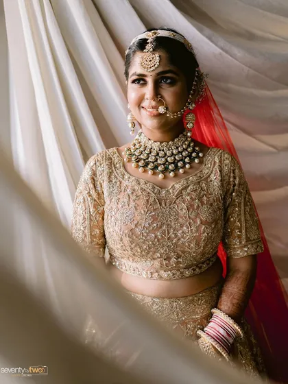 A beautiful bride in her golden wedding attire, her expression serene and her jewelry sparkling. A classic and timeless bridal portrait.