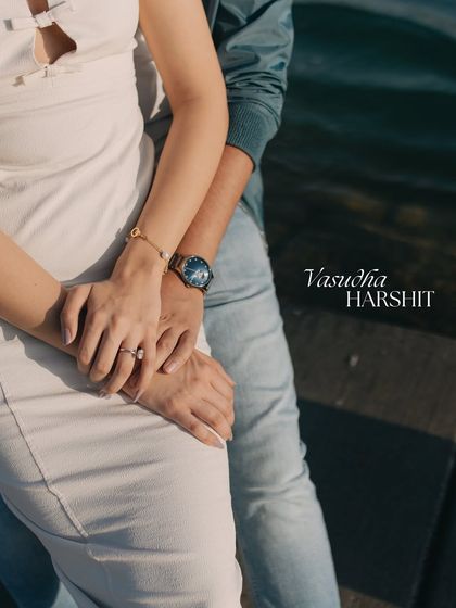 A close-up detail shot of hands intertwined, showcasing the engagement ring against the backdrop of Qatar's waters. We believe the little details tell a big story.