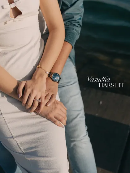 A close-up detail shot of hands intertwined, showcasing the engagement ring against the backdrop of Qatar's waters. We believe the little details tell a big story.