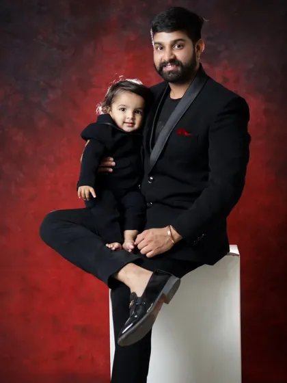 A stylish father and son portrait. The matching black outfits and the confident pose make this a very special and memorable photo.