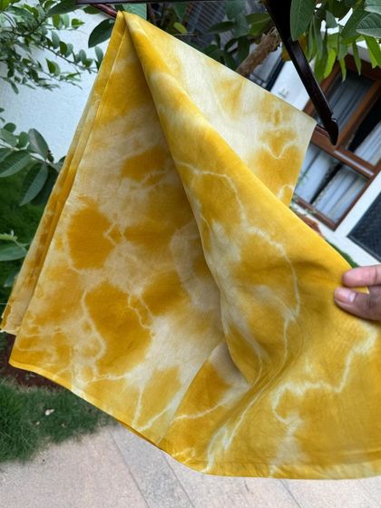 The beautiful, subtle variations in color on this marigold-dyed saree are a hallmark of the natural dyeing process.