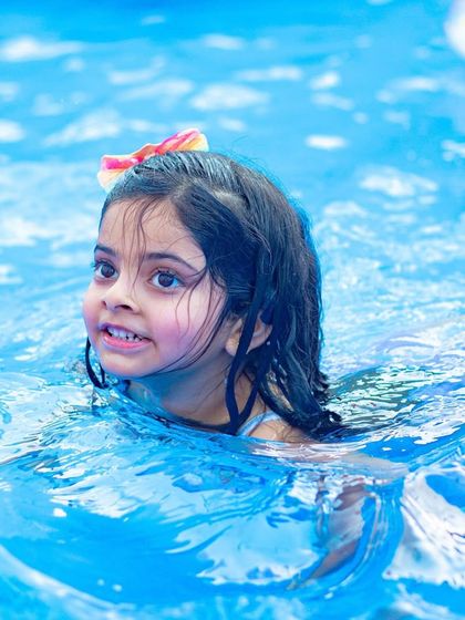 A serene shot of a little girl swimming peacefully. Amidst all the high-energy fun, there are always moments of simple joy.