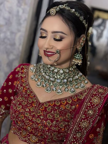 A close-up on the details. This image highlights the stunning combination of gold eyeshadow, a bold red lip, and the intricate work on her polki and emerald jewelry.
