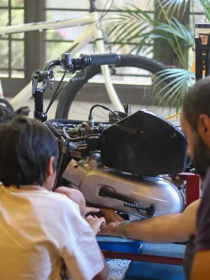A young tinkerer gets a close look at a scooter engine as I explain how it works. It's one thing to see it in a diagram, but another to see and touch the real thing.