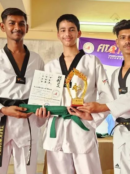 Another successful student receives his green belt and trophy. We are proud to guide our students as they advance through the ranks.