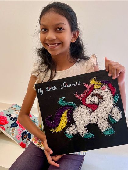 Unicorn magic brought to life with string. This young artist is so happy with her colorful and imaginative unicorn string art.