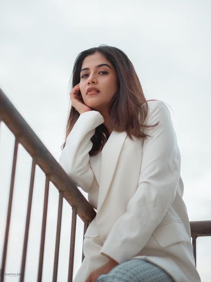 A rooftop portrait with a clean, minimalist feel. The white blazer and the bright, open sky create a high-key look that is both modern and sophisticated.
