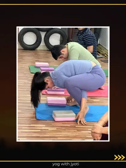 A student works on lifting into Bhujapidasana with the help of yoga blocks.