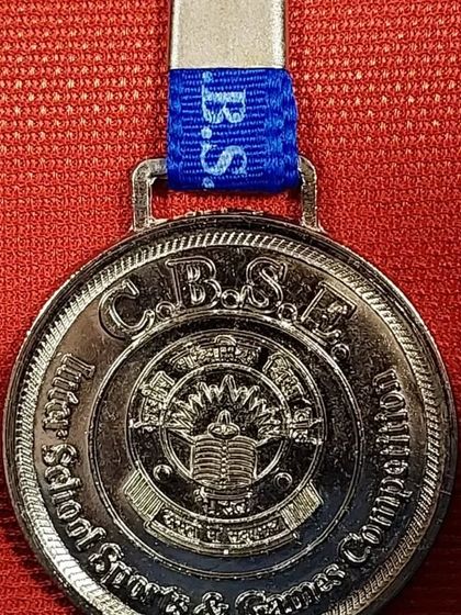 A close-up of a CBSE Inter-School Sports & Games Competition medal, a symbol of achievement for young school athletes.