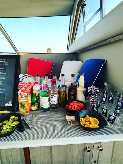 A closer look at our mobile bar setup on a yacht. We come prepared with everything needed, including a variety of spirits, fresh juices, and garnishes like strawberries and oranges, for a perfect day at sea.