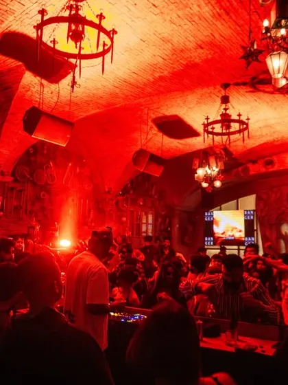 A wide shot of the unique venue in Indore, showing the entire club pulsating with red light and energy. I love playing in spaces with character.