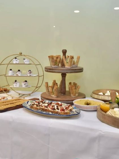 A wide view of the complete grazing table setup for Clinic Dermatech. The clean white tablecloth and wooden serveware create a fresh and modern look.