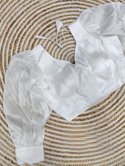 A classic white organza blouse with balloon sleeves, a versatile and trendy piece.