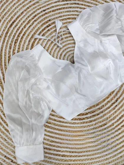 A classic white organza blouse with balloon sleeves, a versatile and trendy piece.