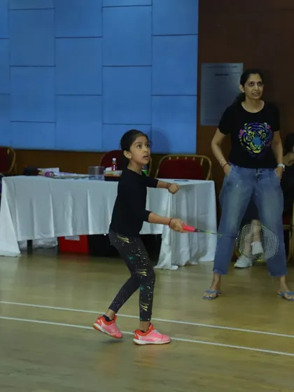 A young girl plays a match under the watchful eye of her coach. We create a safe and encouraging environment for our youngest players.