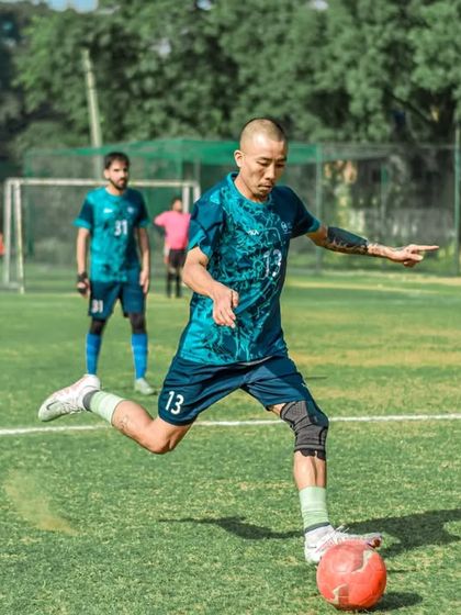 A player strikes the ball with power and precision. Our well-maintained natural grass fields provide the perfect surface for high-quality football.